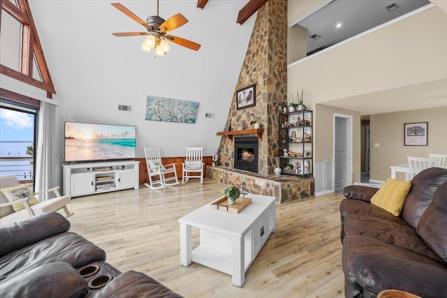 living room with a fireplace, ceiling fan, light wood-type flooring, and high vaulted ceiling