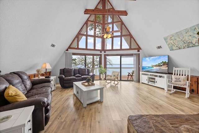 living room featuring high vaulted ceiling, a wealth of natural light, and light hardwood / wood-style floors