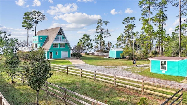 view of yard with a garage, a rural view, and a shed