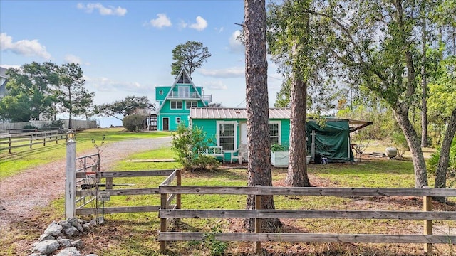 view of front of home featuring a rural view and a front lawn