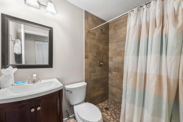 bathroom featuring vanity, a textured ceiling, curtained shower, and toilet