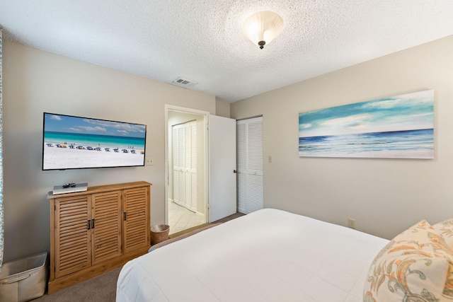 bedroom featuring light colored carpet and a textured ceiling