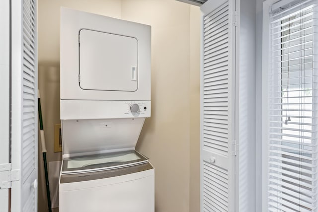 clothes washing area featuring stacked washer / dryer