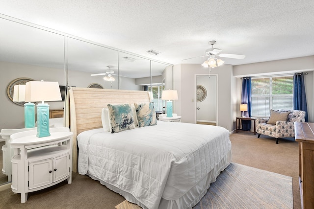 carpeted bedroom featuring a textured ceiling and ceiling fan