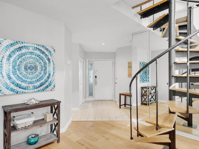 entryway featuring light hardwood / wood-style floors and a textured ceiling