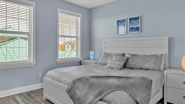 bedroom with hardwood / wood-style flooring and multiple windows