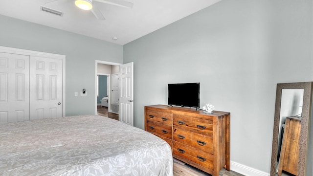 bedroom with light hardwood / wood-style floors, ceiling fan, and a closet