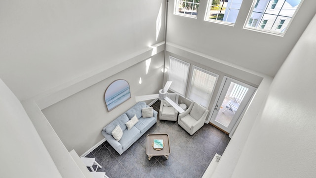 tiled living room featuring a towering ceiling and a healthy amount of sunlight