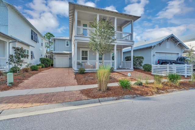 view of front of property featuring a garage, a balcony, and a porch