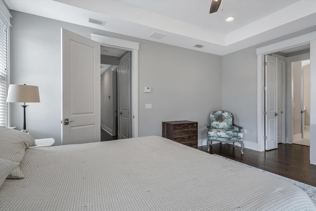 bedroom featuring ceiling fan, dark hardwood / wood-style flooring, and multiple windows