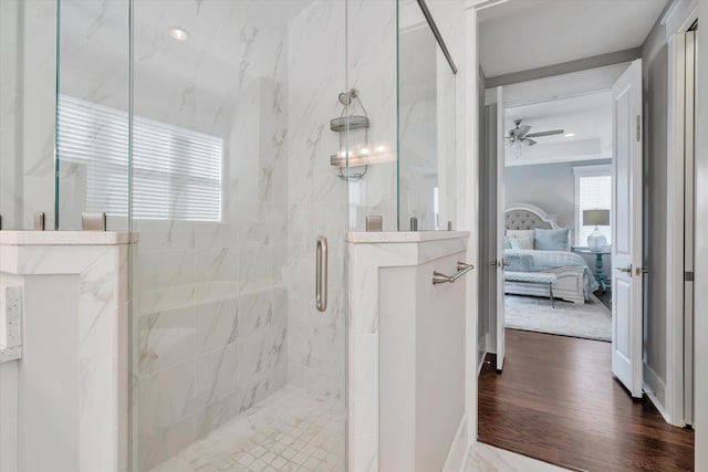 bathroom featuring a shower with door, wood-type flooring, and ceiling fan