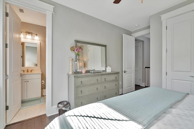 bedroom featuring sink, hardwood / wood-style flooring, and ensuite bath