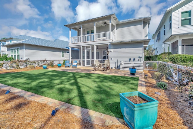 back of house with ceiling fan, a yard, a patio, a sunroom, and a balcony