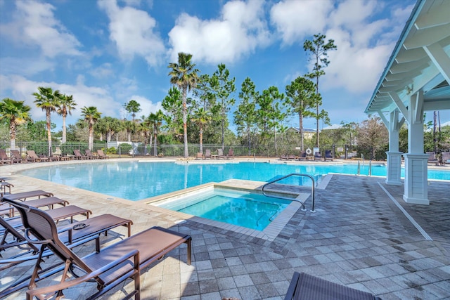 view of pool featuring a hot tub and a patio