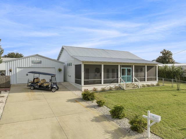 view of front facade featuring a sunroom, a garage, an outdoor structure, and a front yard