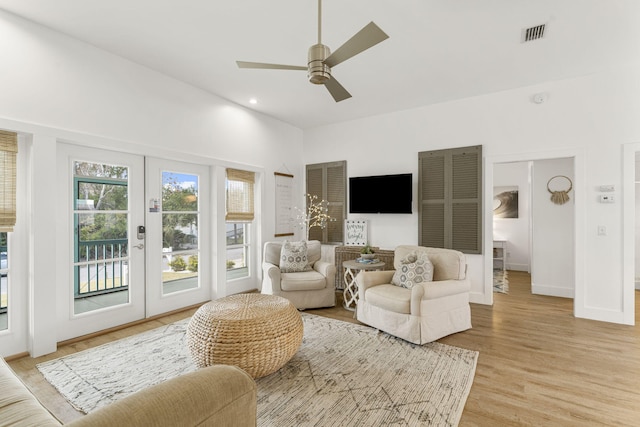 living room with ceiling fan, light hardwood / wood-style floors, and french doors