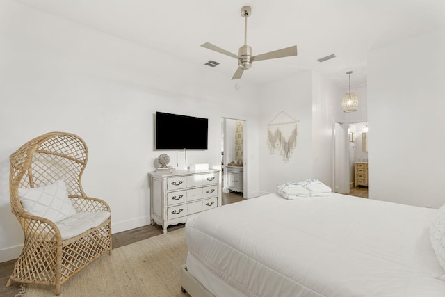 bedroom with ceiling fan, wood-type flooring, and ensuite bath