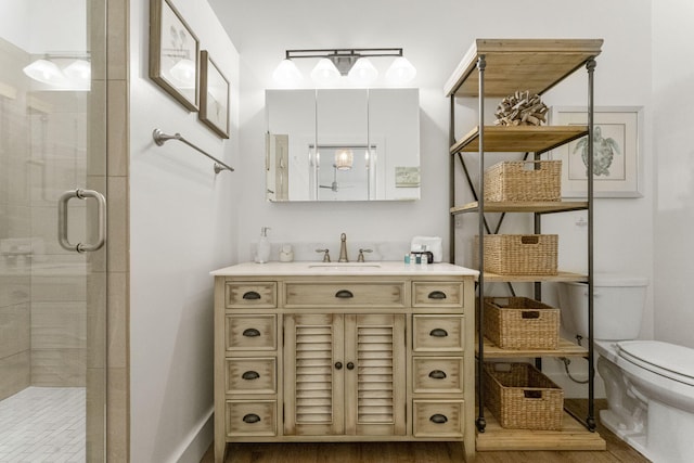 bathroom with vanity, toilet, a shower with shower door, and wood-type flooring