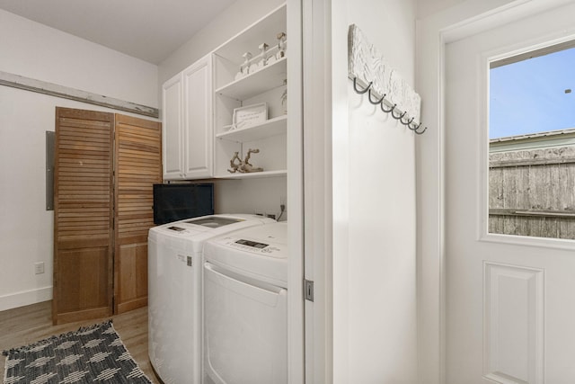 laundry room featuring separate washer and dryer, dark wood-type flooring, and cabinets