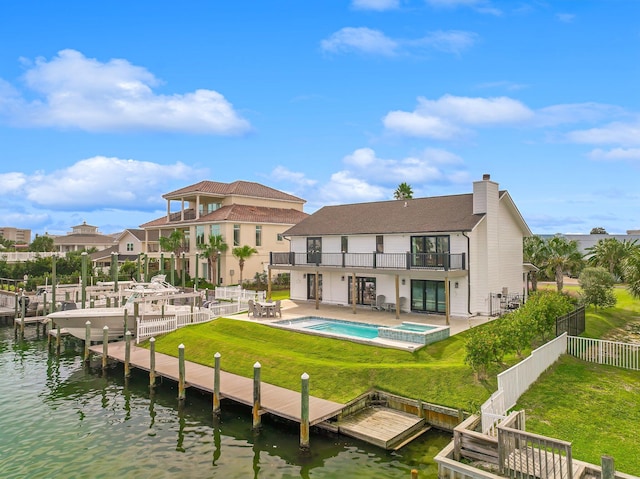 rear view of house with a pool with hot tub, a yard, a patio, a water view, and a balcony