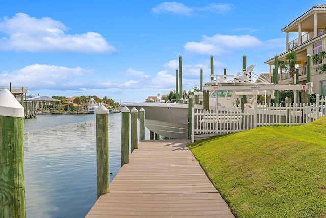 view of dock with a yard and a water view