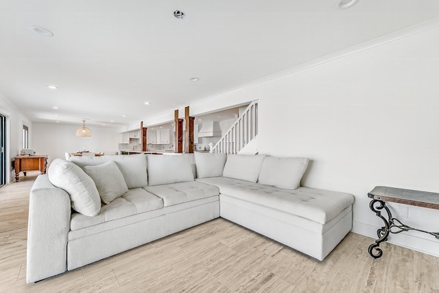 living room with ornamental molding and light wood-type flooring