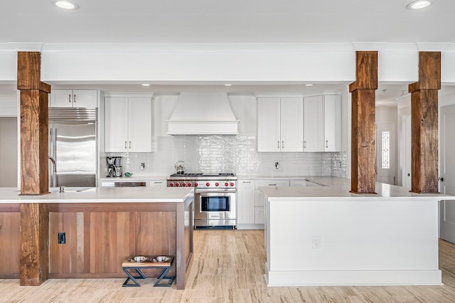 kitchen featuring premium range hood, white cabinetry, and high quality appliances