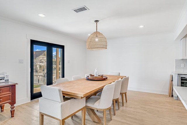 dining area with ornamental molding and light wood-type flooring