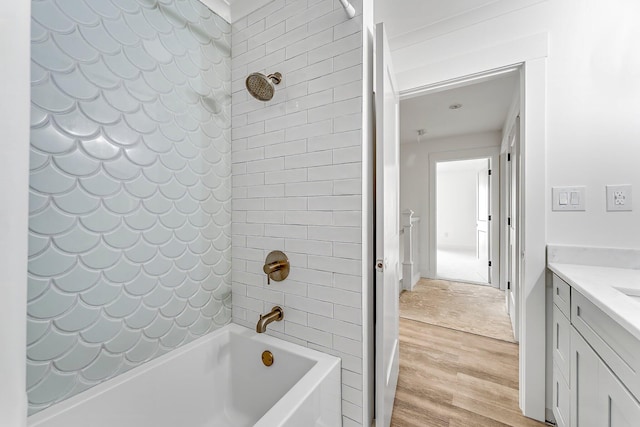 bathroom featuring vanity, tiled shower / bath combo, and wood-type flooring