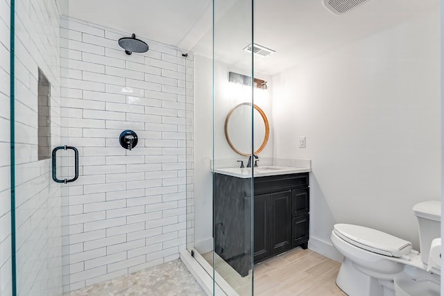 bathroom featuring vanity, hardwood / wood-style floors, toilet, and an enclosed shower