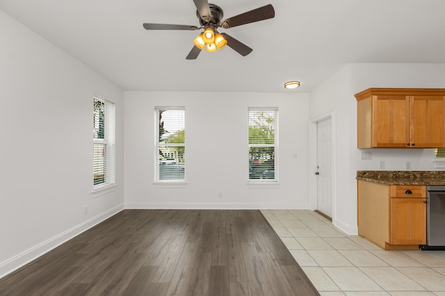 kitchen featuring dark stone counters, ceiling fan, and light hardwood / wood-style floors