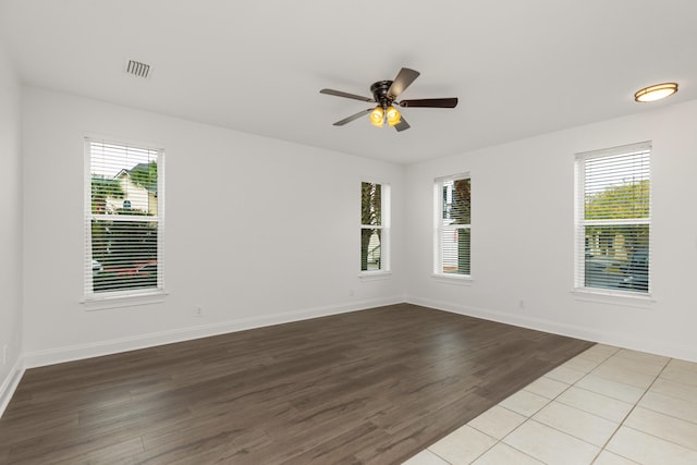 empty room featuring ceiling fan, a healthy amount of sunlight, and light hardwood / wood-style floors