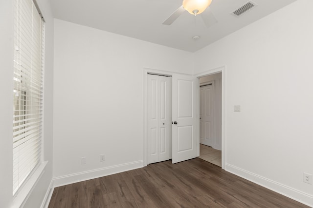 unfurnished bedroom featuring ceiling fan, a closet, and dark hardwood / wood-style floors