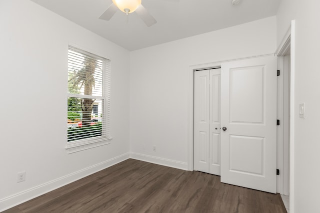 unfurnished bedroom with ceiling fan, dark hardwood / wood-style flooring, and a closet