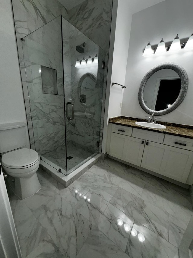 bathroom featuring vanity, toilet, and a shower with shower door