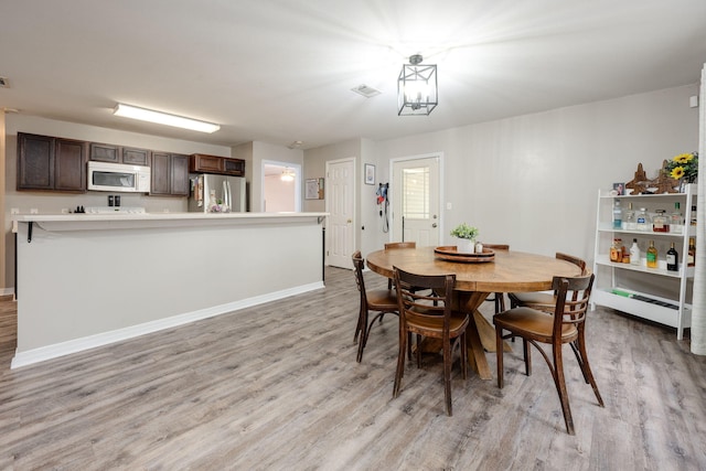 dining area with light hardwood / wood-style flooring and a baseboard radiator