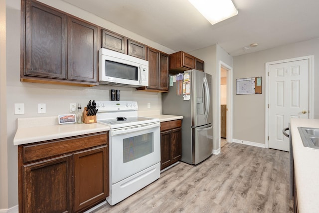 706 Brock Ave, Crestview, FL 32539 - kitchen featuring white appliances, light wood-style floors, light countertops, and baseboards