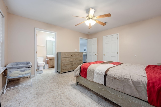 bedroom featuring ceiling fan, ensuite bath, and light colored carpet