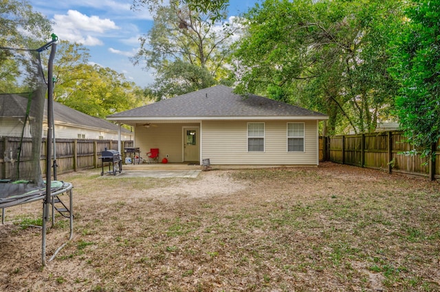706 Brock Ave, Crestview, FL 32539 - rear view of house featuring a trampoline, a patio area, and a shingled roof