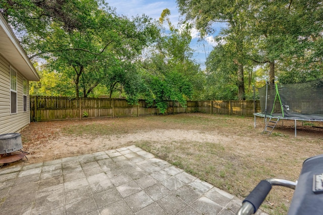 706 Brock Ave, Crestview, FL 32539 - fenced backyard featuring a trampoline, a patio area, and view of wooded area