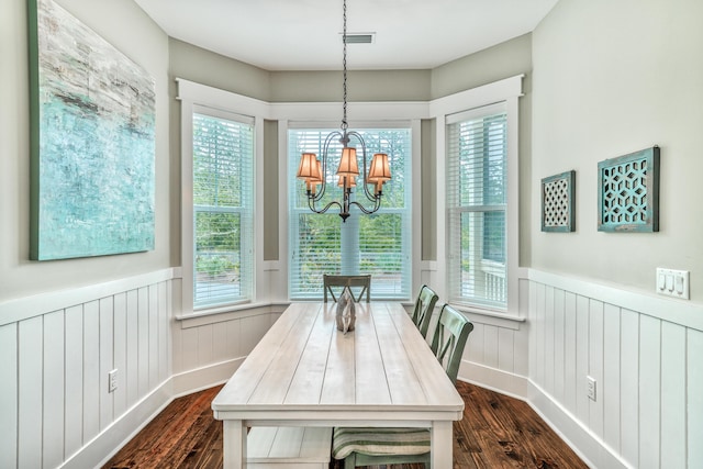 dining room with dark wood-type flooring and a chandelier