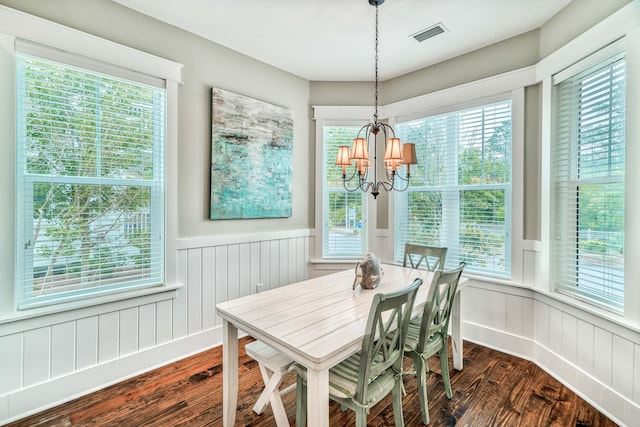 dining area with a wealth of natural light, a chandelier, and dark hardwood / wood-style floors