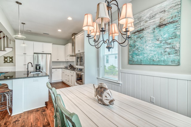 dining room with sink, dark hardwood / wood-style flooring, and an inviting chandelier