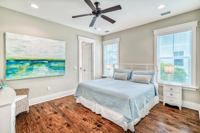 bedroom featuring dark wood-type flooring, multiple windows, and ceiling fan