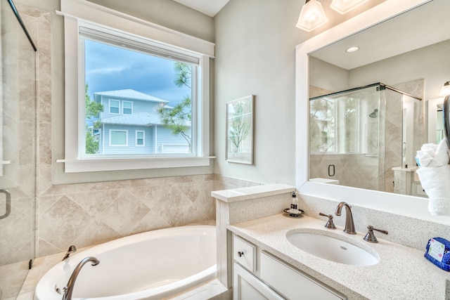 bathroom with vanity and shower with separate bathtub