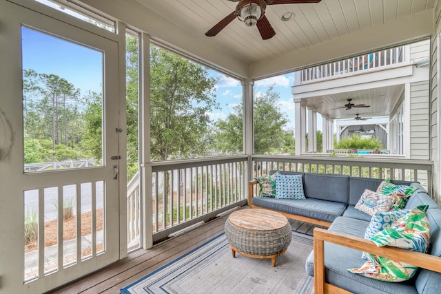 sunroom / solarium with ceiling fan, wooden ceiling, and a wealth of natural light