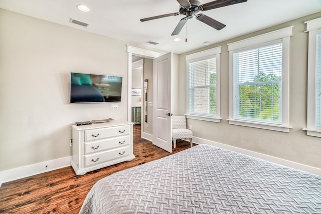 bedroom with dark hardwood / wood-style flooring and ceiling fan