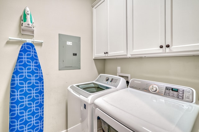 washroom featuring electric panel, independent washer and dryer, and cabinets