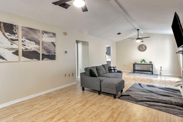 living room with light hardwood / wood-style floors, ceiling fan, and lofted ceiling with beams