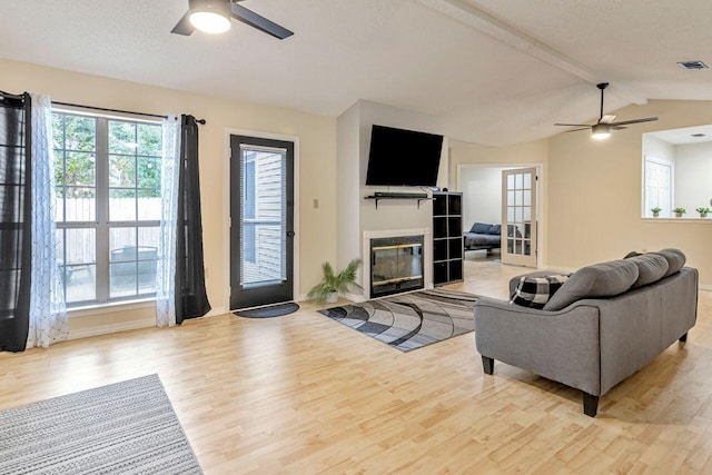 living room with vaulted ceiling, ceiling fan, and light hardwood / wood-style flooring